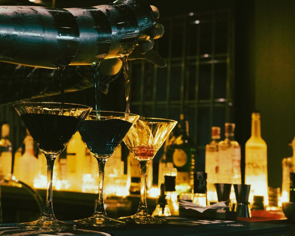 Cocktails lined up on a bar at night