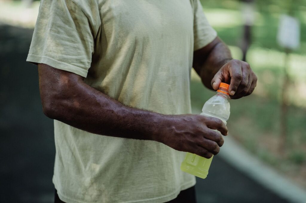 A man opening a bottle of electrolyte drink
