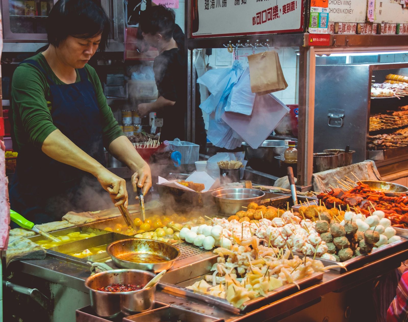 A cook at a busy Thai street food stall