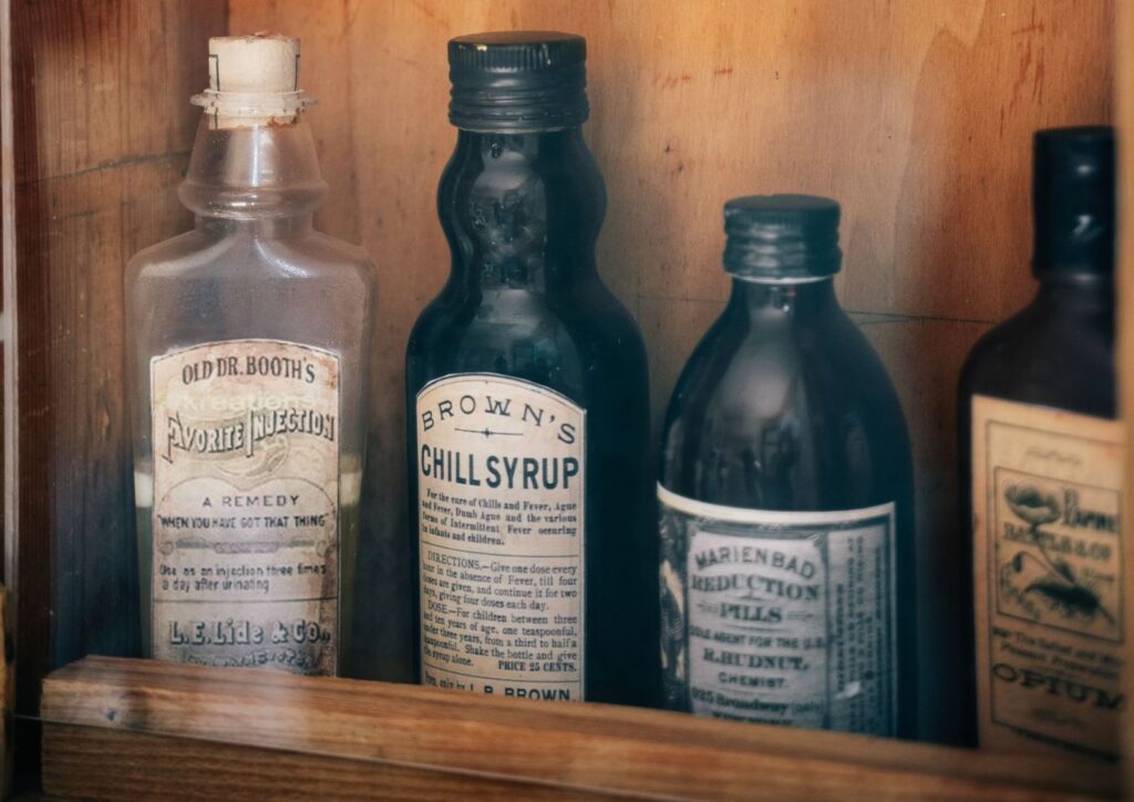 Old medicine bottles on a wooden shelf
