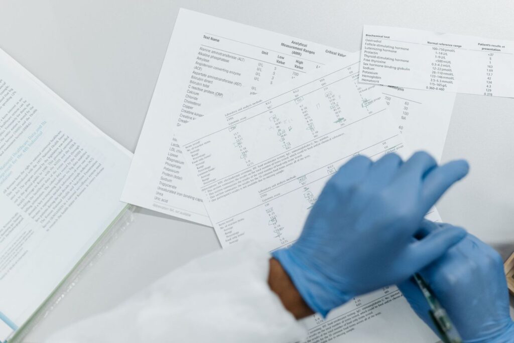 A researcher in gloves reviewing printed study results