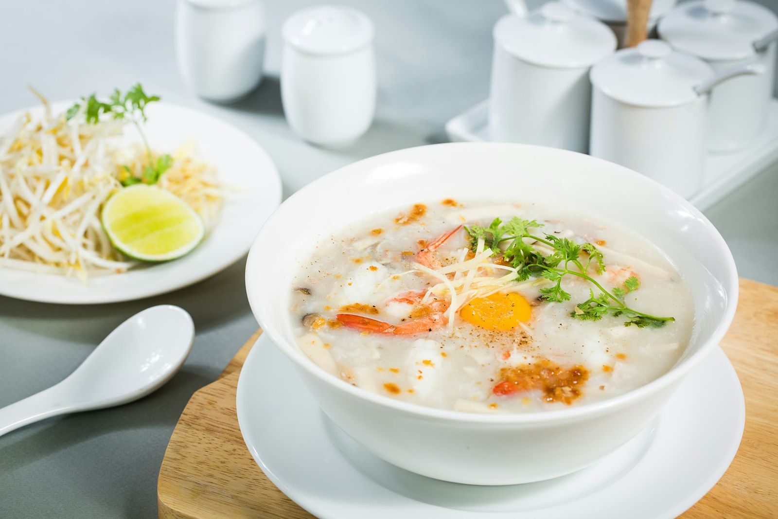 A bowl of rice porridge with egg and herbs