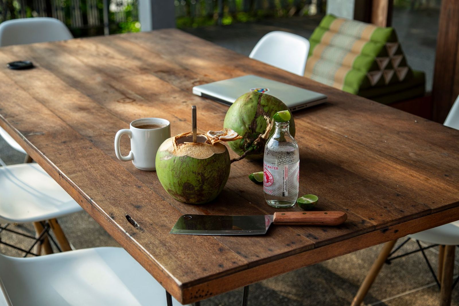 Fresh coconut, water and coffee on a table in a tropical café