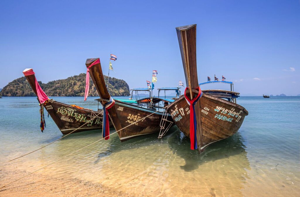 Longtail boats waiting on a bright Thai beach