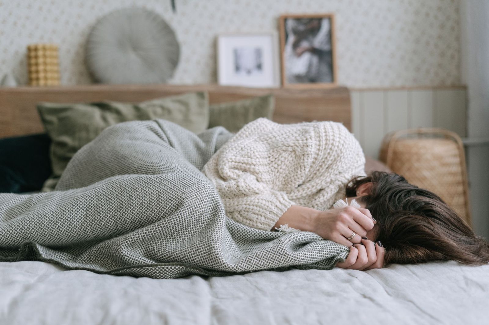 A woman curled up in bed feeling unwell