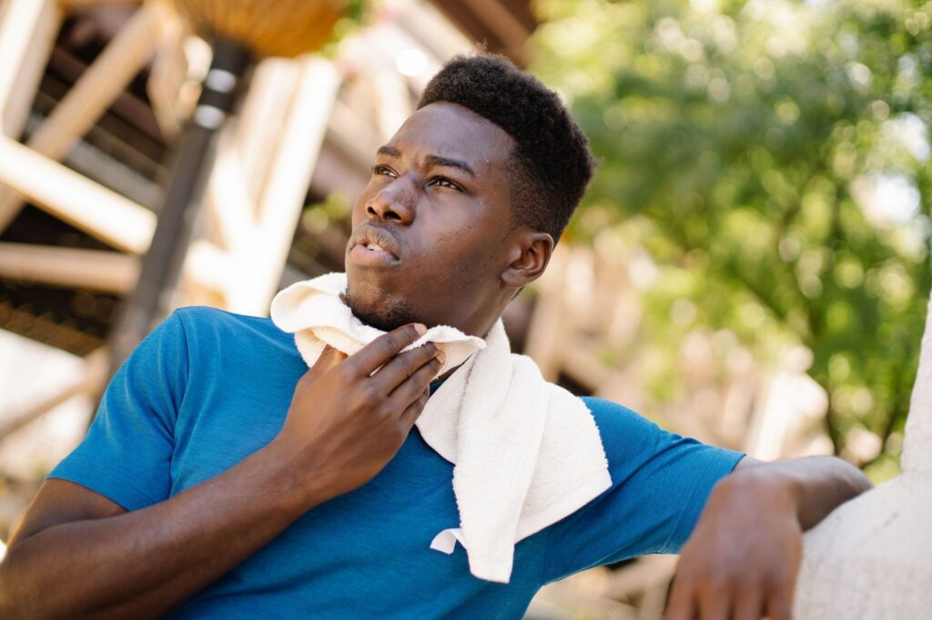 A man cooling down with a towel around his neck