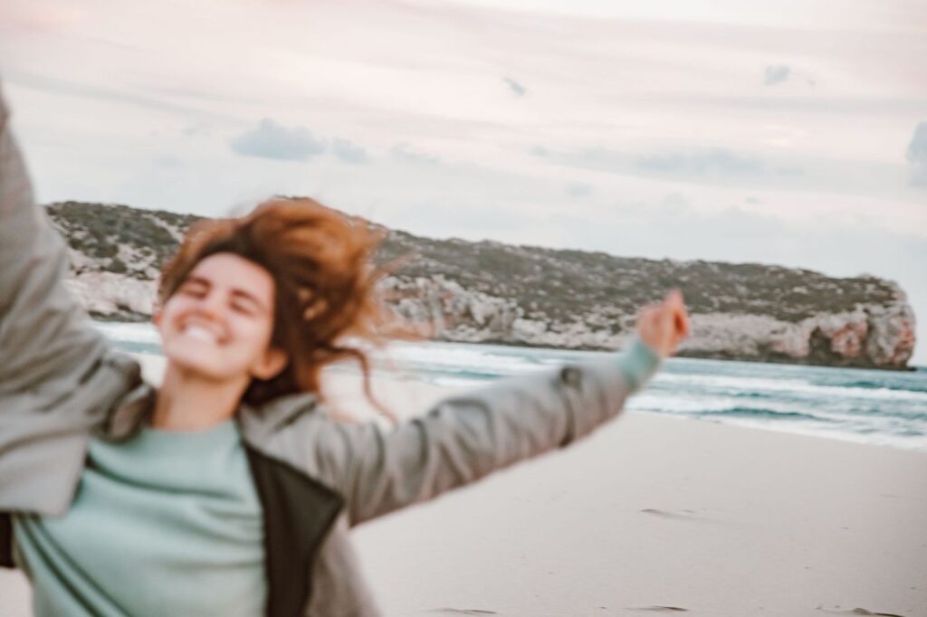 A woman smiling on a windy beach