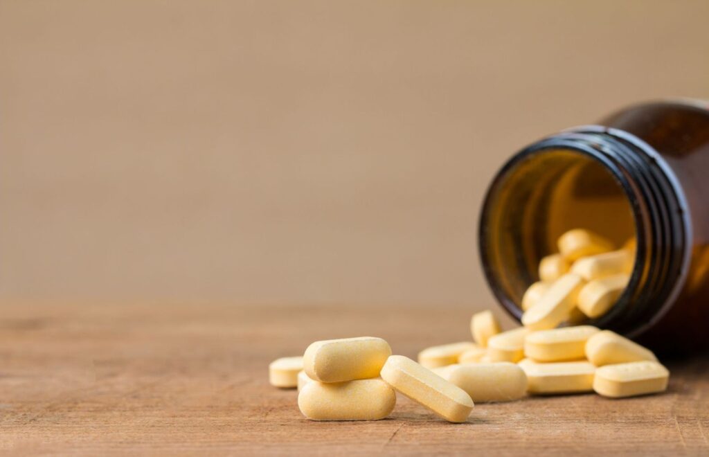 Vitamin tablets spilling from a bottle