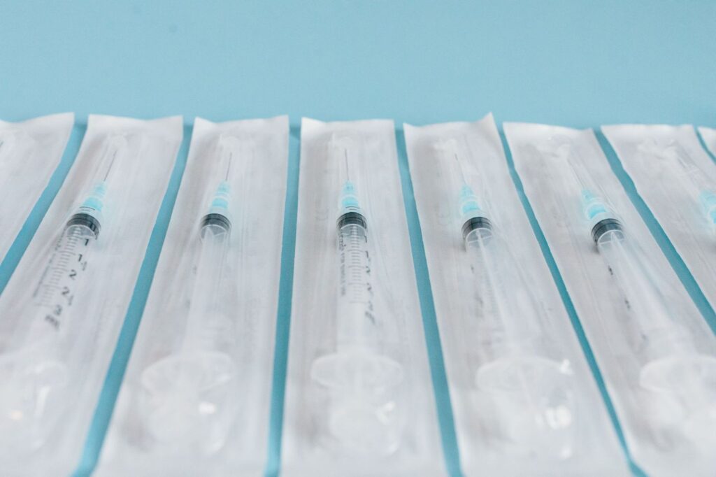 A row of sealed, single-use syringes