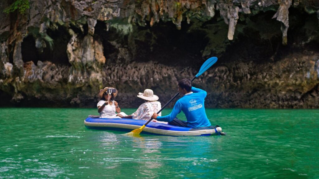 A group kayaking through limestone caves in Krabi