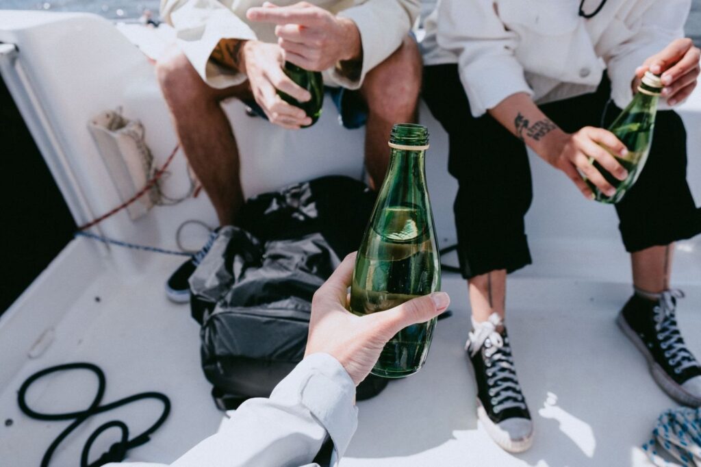 Friends drinking from bottles on a boat deck