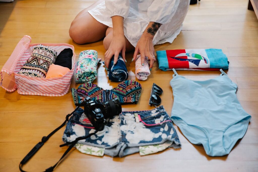 Swimwear, a camera and travel essentials laid out for packing