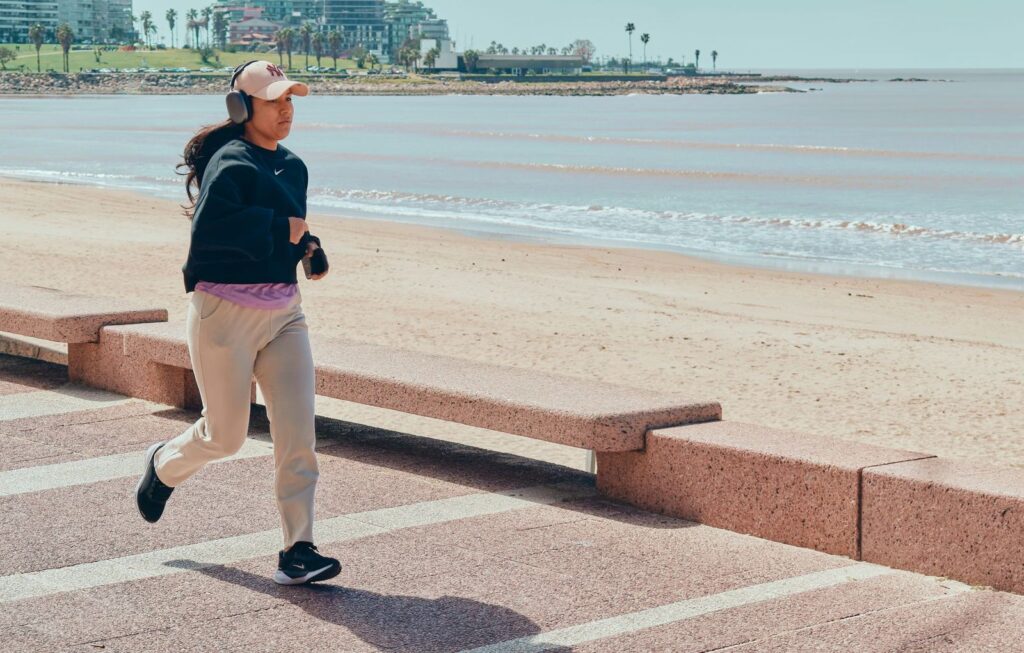A woman jogging along a beachfront