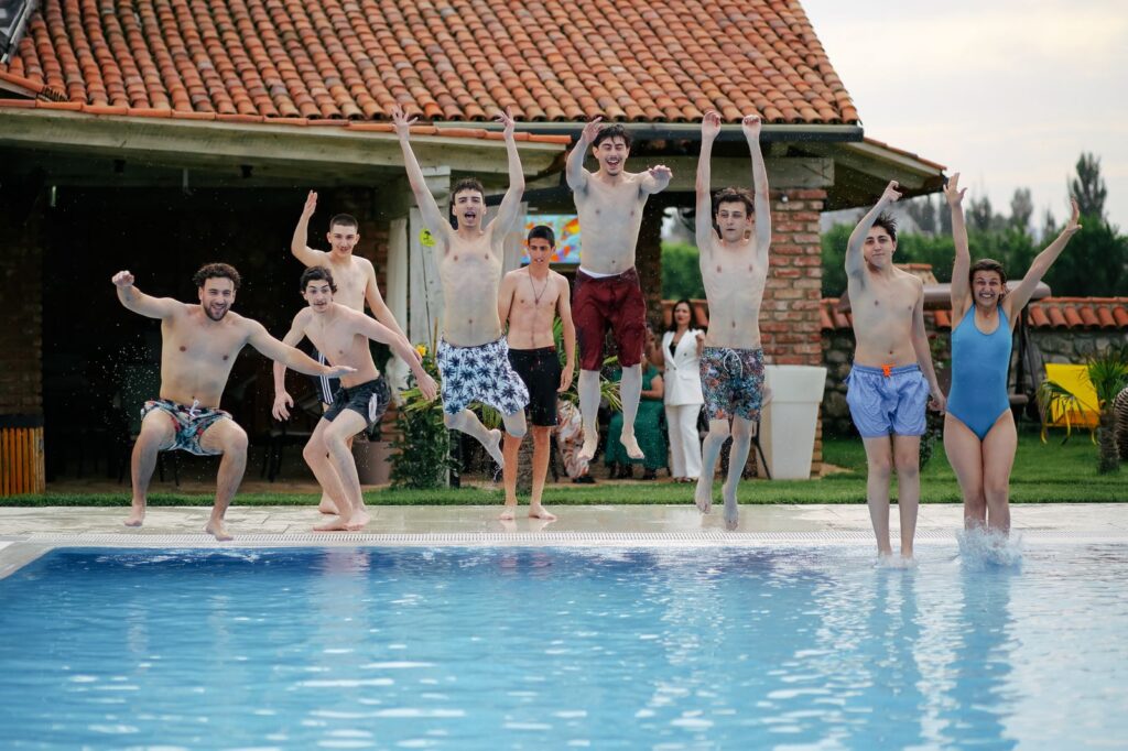 Friends jumping into a villa swimming pool