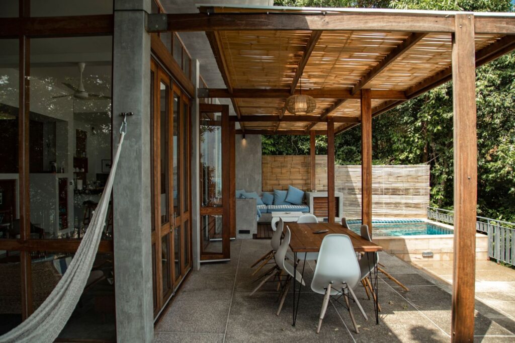 A shaded villa terrace with a long dining table for a group