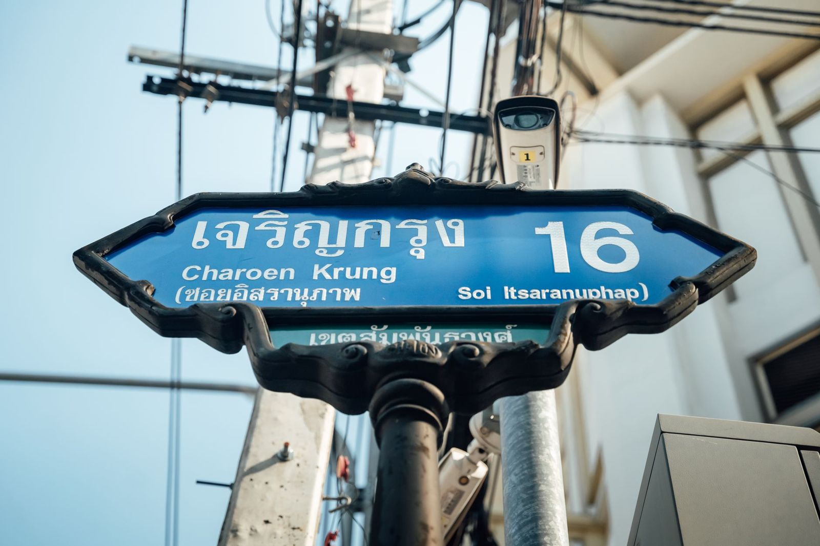 A street sign written in Thai script and English