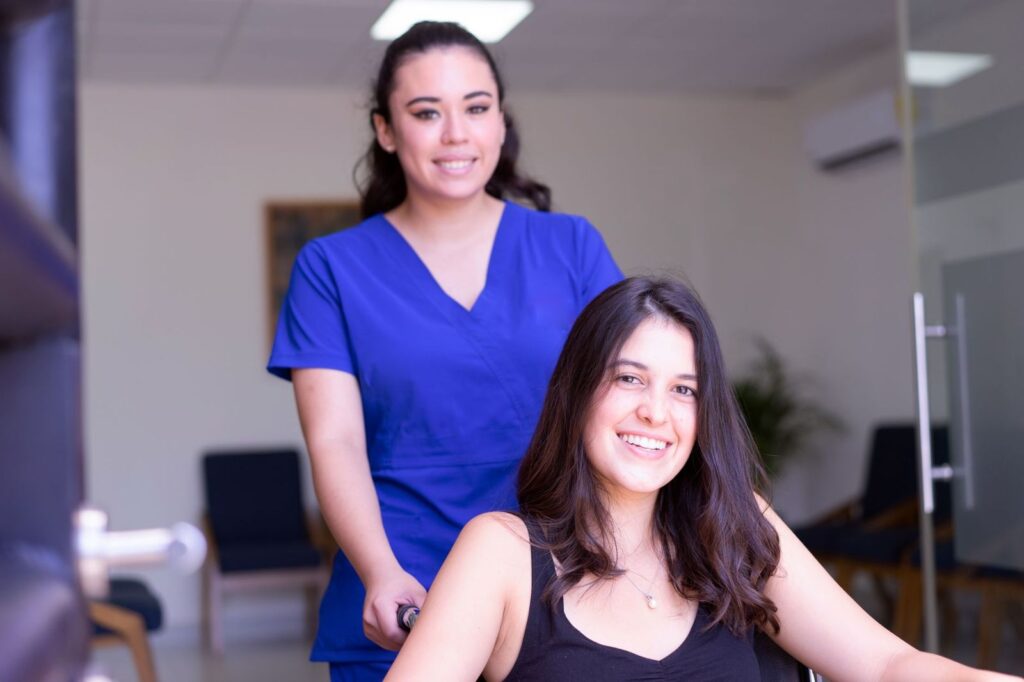 A nurse standing behind a smiling patient