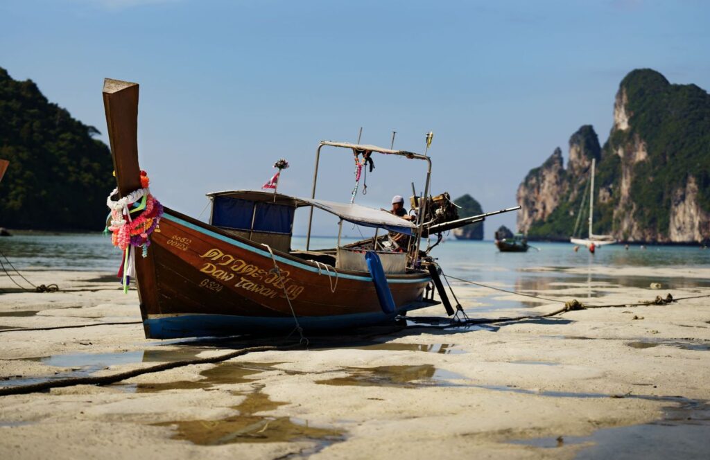 A longtail boat on a Krabi beach at low tide