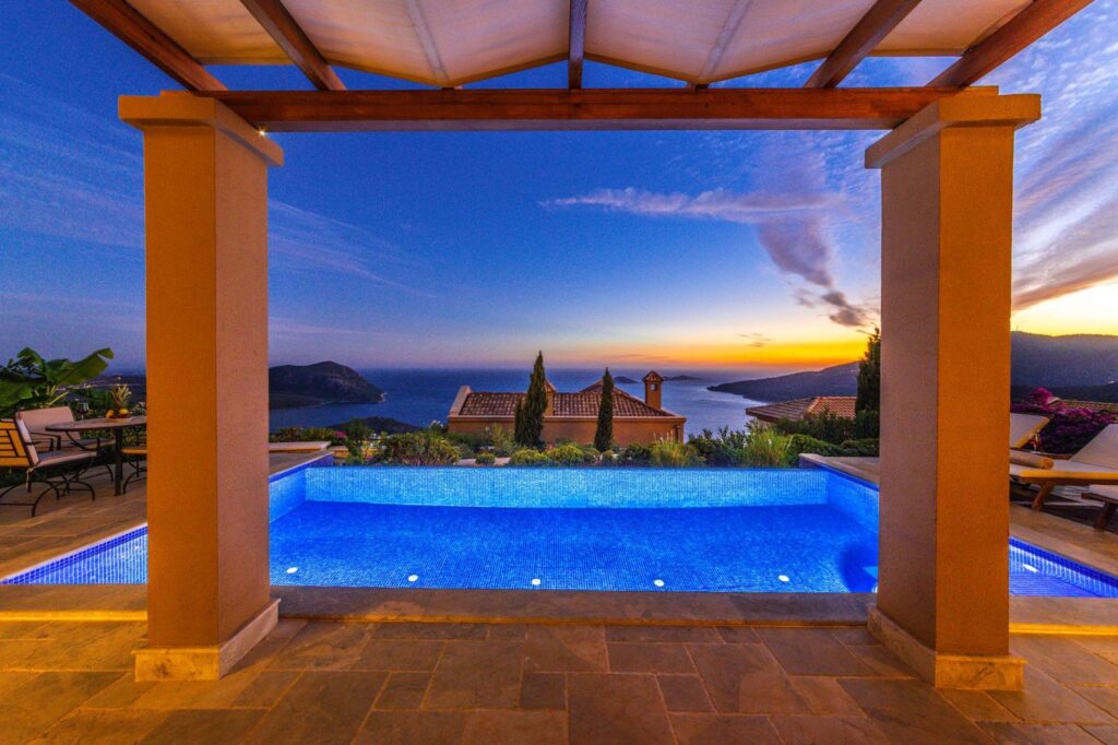 A villa infinity pool overlooking the sea at sunset