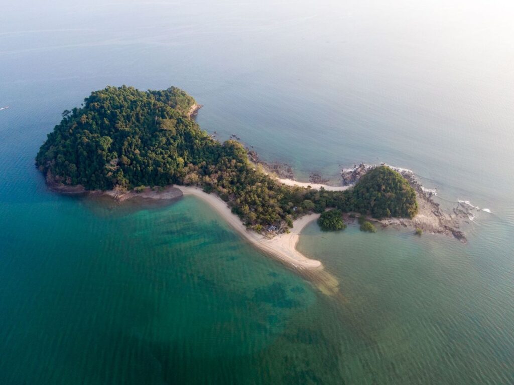 Aerial view of a small forested island in a calm sea