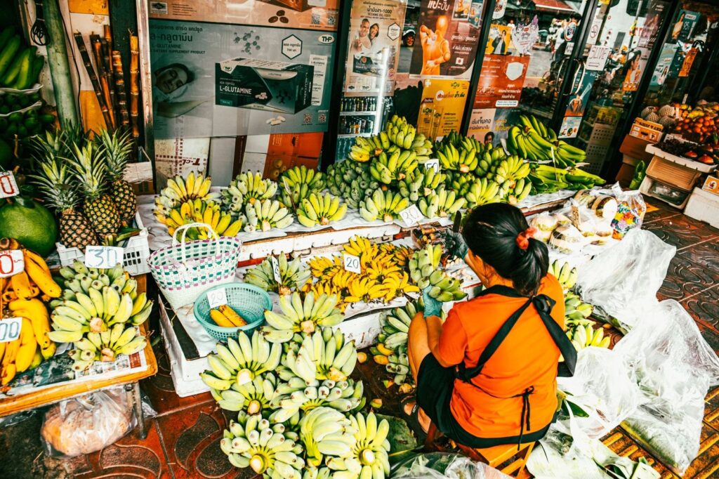 A fruit stall piled with bananas and pineapples