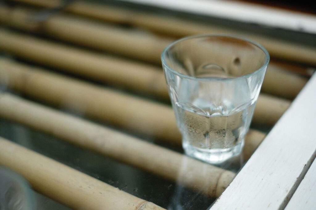 A glass of water on a bamboo table