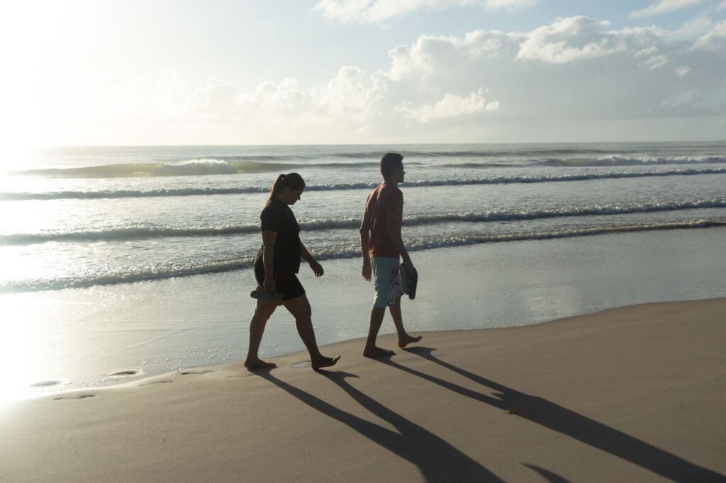 A couple walking along the beach in morning light