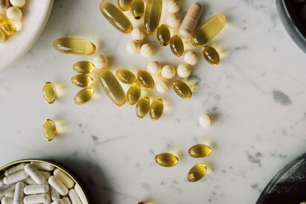 Vitamin capsules and tablets on a marble table