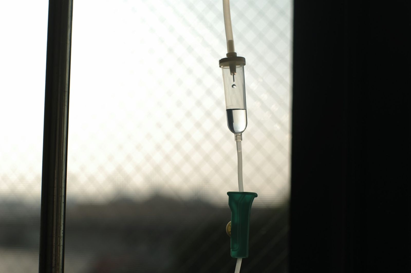 An IV drip line hanging by a window