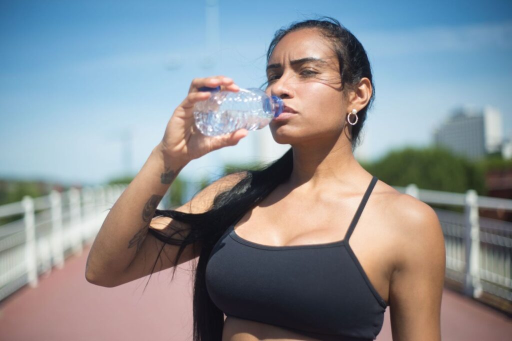 A woman drinking water on a hot day