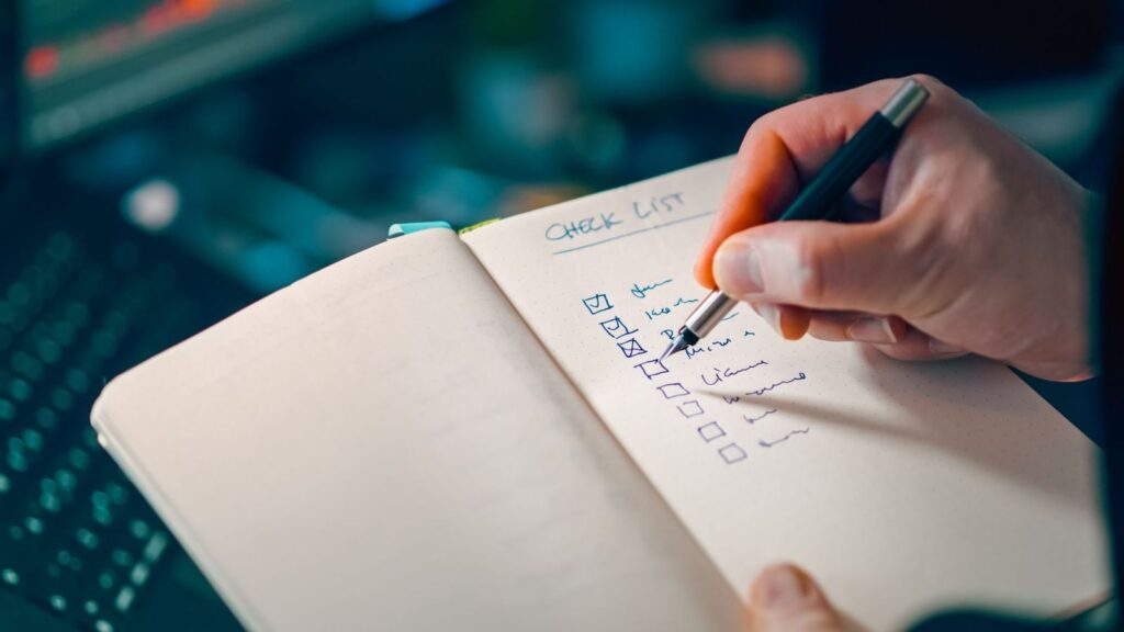 Writing a checklist in a notebook