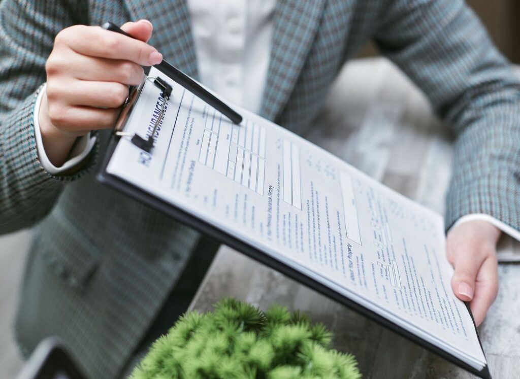 Someone holding a clipboard with an insurance form