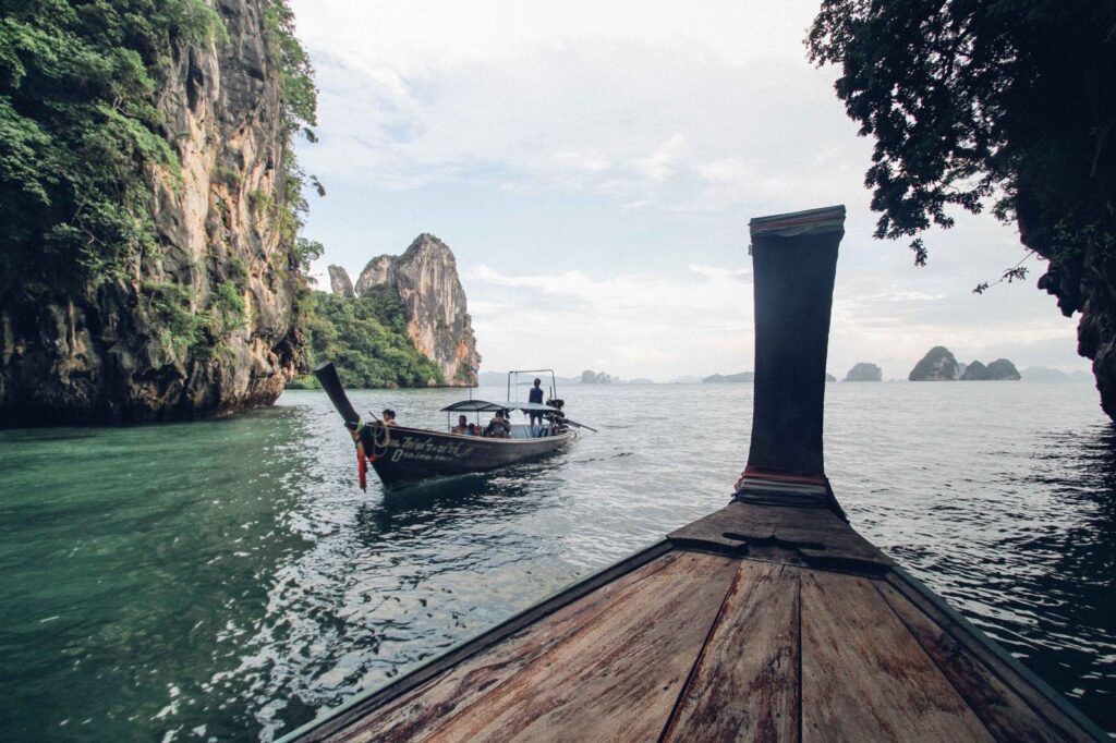 View from the bow of a longtail boat heading towards limestone islands
