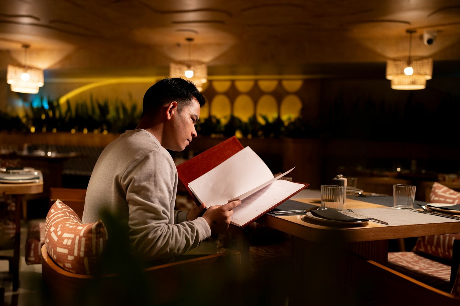 A man reading a menu, choosing what to order